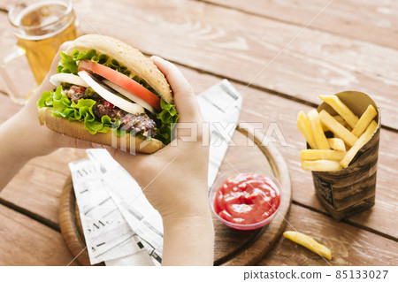 high angle hands holding burger burger fries. High quality photo high angle hands holding burger burger fries. High quality photo 85133027