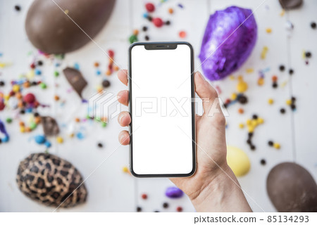 person holding smartphone with blank screen easter eggs. High quality photo 85134293