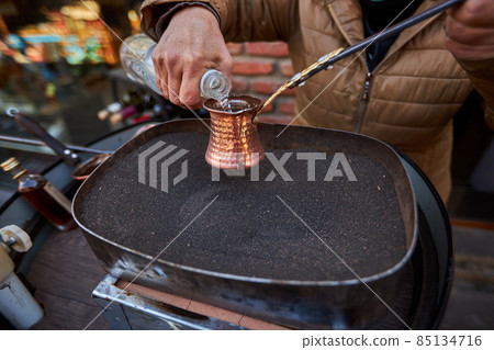 Aromatic coffee brewed in hot sand turkish coffee brewing in cezve Aromatic coffee brewed in hot sand turkish coffee brewing in cezve 85134716