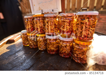Assortment of honey jars at market stall. Sale of natural honey in fair outdoor. Production of honey 85134718