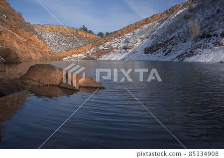 mountain lake with sandstone cliffs and snow 85134908