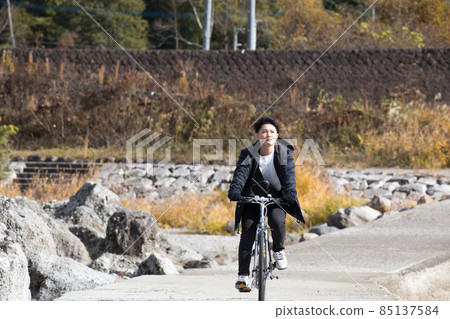 A man cycling on a subsidence bridge with a view of dog stone dogs 85137584