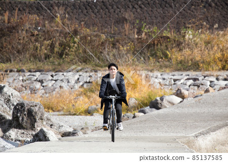 A man cycling on a subsidence bridge with a view of dog stone dogs 85137585