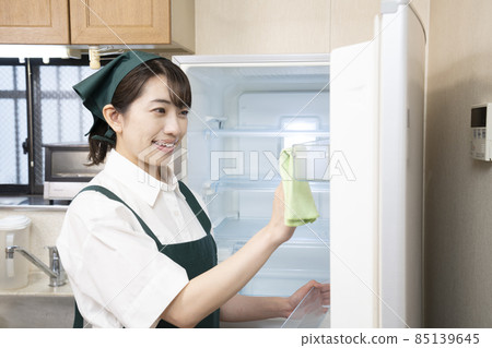 Woman housekeeper cleaning the fridge 85139645