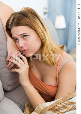 sad female on cozy sofa at home sad female on cozy sofa at home 85142193