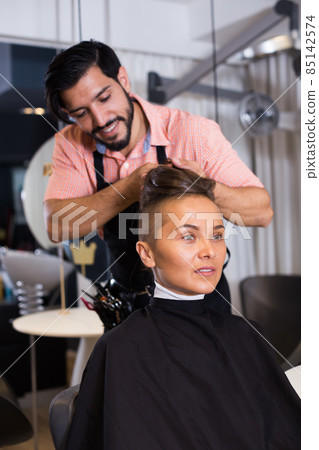 Smiling male hairdresser making hairstyle for woman 85142574
