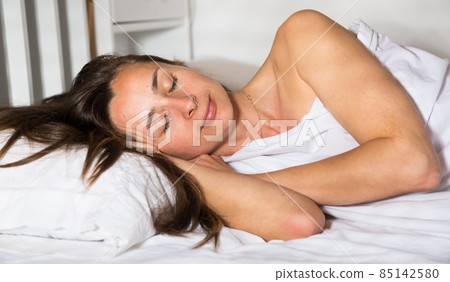 Portrait of relaxed adult woman sleeping in bed alone in home Portrait of relaxed adult woman sleeping in bed alone in home 85142580