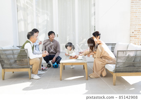 A three-generation family relaxing in the courtyard A three-generation family relaxing in the courtyard 85142908