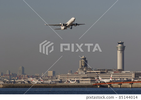 An airplane taking off with the control tower at Haneda Airport 85144014