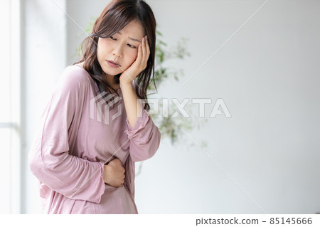 一個生病的女人用手托著她的腹部 85145666