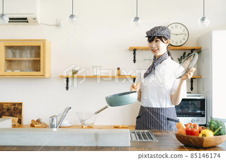 A cook (pot) wearing a cook coat standing in the kitchen A cook (pot) wearing a cook coat standing in the kitchen 85146174