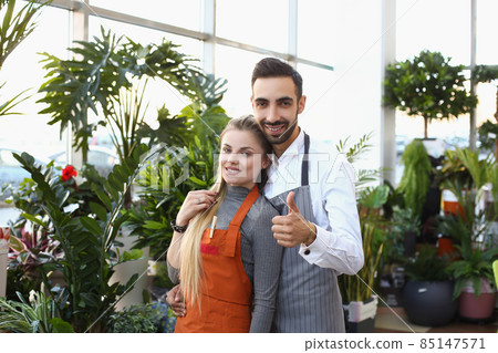 Young male and female consultants work in flower delivery shop and sale indoor plants 85147571