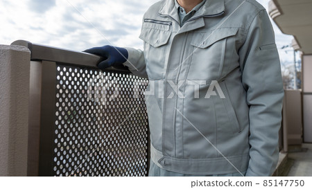 一名工人在公寓陽台上檢查扶手。 85147750