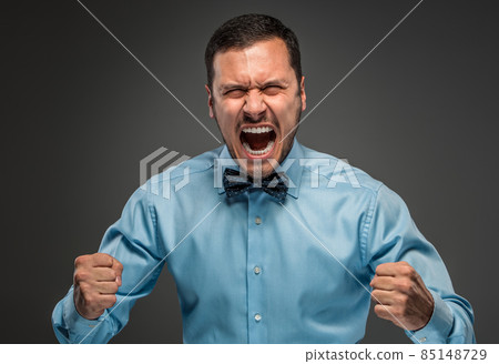 Portrait angry upset young man in blue shirt, butterfly tie 85148729