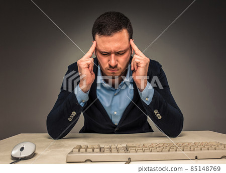 Portrait frustrated young man, hands touch the head 85148769