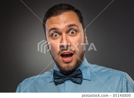 Portrait young man in blue shirt, looking with amazement 85148800