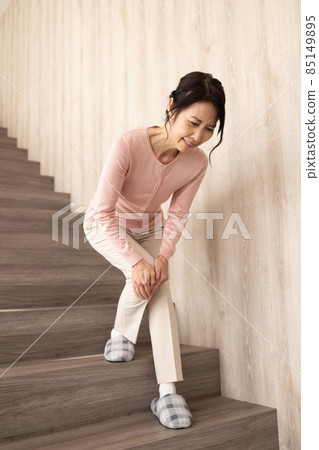 Senior woman descending stairs 85149895