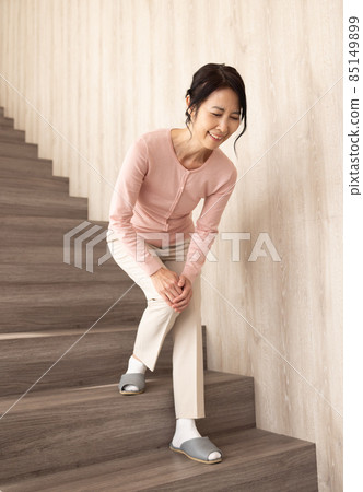 Senior woman descending stairs 85149899