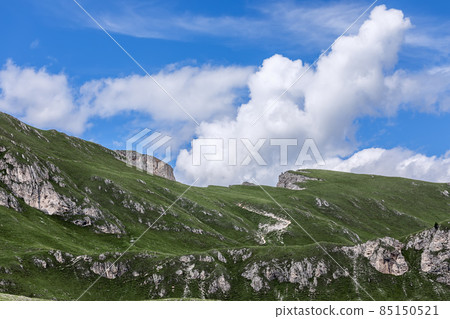 Mountain range covered with fresh green grass in the Italian Dolomites. Natural park Puez Odle 85150521