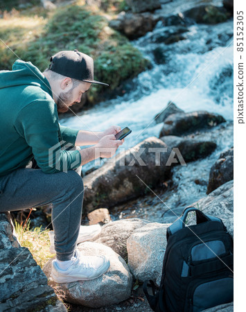 A young man is resting with a phone A young man is resting with a phone 85152305