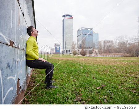 Adult Man running in the parc in winter with city background Adult Man running in the parc in winter with city background 85152559