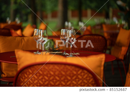 Served dinner table with four empty wine glasses in restaurant terrace in pine wood Served dinner table with four empty wine glasses in restaurant terrace in pine wood 85152687