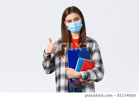 Coronavirus pandemic, covid-19 education, and back to school concept. Pleased young female freshman in college, showing thumb-up as studying prestige univeristy, carry notebooks Coronavirus pandemic, covid-19 education, and back to school concept. Pleased young female freshman in college, showing thumb-up as studying prestige univeristy, carry notebooks 85154680