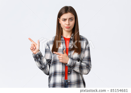 Lifestyle, different emotions, leisure activities concept. Skeptical and unimpressed girl having suspicious thoughts, express disbelief and skepticism, pointing fingers left and smirk displeased Lifestyle, different emotions, leisure activities concept. Skeptical and unimpressed girl having suspicious thoughts, express disbelief and skepticism, pointing fingers left and smirk displeased 85154681