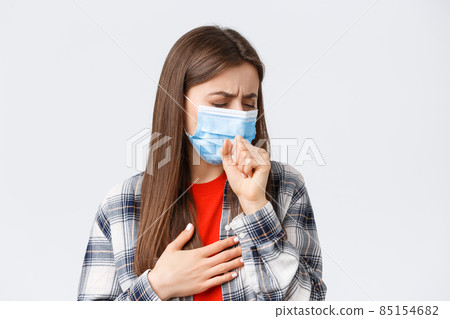 Coronavirus outbreak, leisure on quarantine, social distancing and emotions concept. Close-up of sick young woman in medical mask staying at home during covid-19, cough with closed eyes 85154682