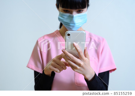 女醫護人員穿著使用智能手機的磨砂膏 過度勞累、換工作、離職、解決問題 85155259