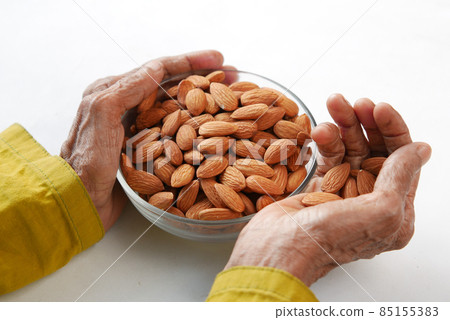 close up senior women hand holding a bowl on almond  85155383