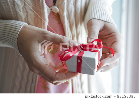 women hand holding small heart shape gift box  85155385