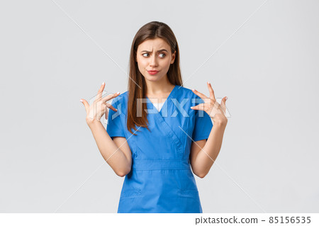 Healthcare workers, prevent virus, insurance and medicine concept. Concerned and bothered young female intern or nurse feeling reluctant and disgusted touching something nasty, grimacing Healthcare workers, prevent virus, insurance and medicine concept. Concerned and bothered young female intern or nurse feeling reluctant and disgusted touching something nasty, grimacing 85156535