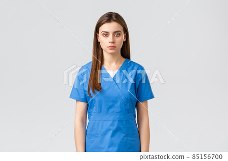 Healthcare workers, prevent virus, insurance and medicine concept. Serious-looking young medical worker, nurse or doctor in blue scrubs, looking determined and confident camera Healthcare workers, prevent virus, insurance and medicine concept. Serious-looking young medical worker, nurse or doctor in blue scrubs, looking determined and confident camera 85156700