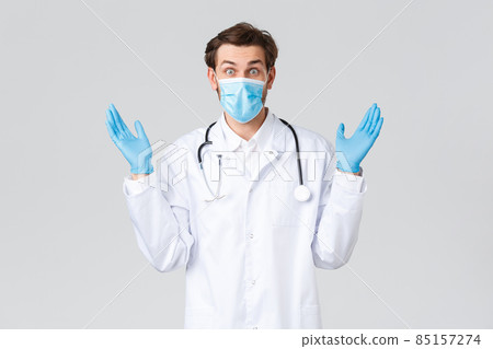 Hospital, healthcare workers, covid-19 treatment concept. Troubled doctor have lots of patients, physician comping with stress work, wearing scrubs, gloves and medical mask, grey background 85157274