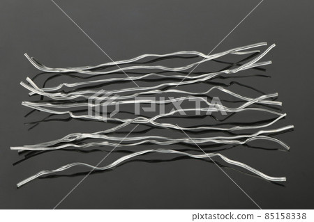 White plastic coated wire tie used for a variety of things on black acrylic background. 85158338