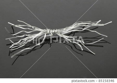 White plastic coated wire tie used for a variety of things on black acrylic background. White plastic coated wire tie used for a variety of things on black acrylic background. 85158346