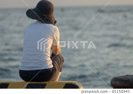 Nostalgic scenery of the back of a woman standing while looking at the sea 85158945