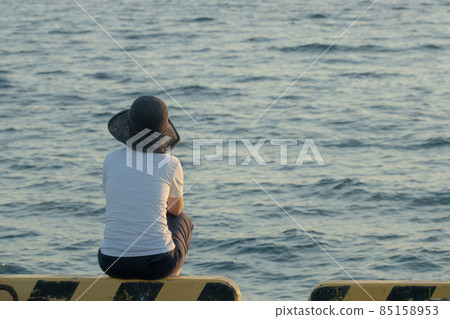 Nostalgic scenery of the back of a woman standing while looking at the sea 85158953