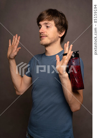 Young man with smoothie on grey background Young man with smoothie on grey background 85159194