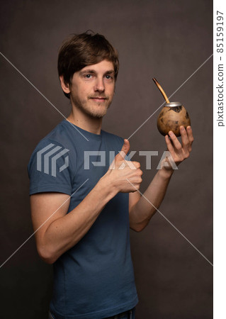 Man with mate cup on grey background Man with mate cup on grey background 85159197