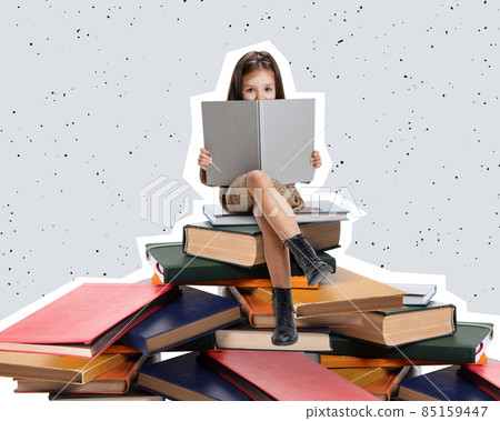 Creative design curious little girl, child sitting on stack of books and reading isolated over gray background Creative design curious little girl, child sitting on stack of books and reading isolated over gray background 85159447