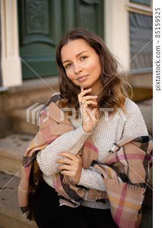 Pretty woman with curly hair near old building Pretty woman with curly hair near old building 85159525