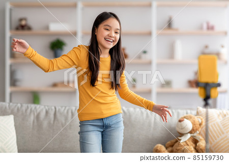 Happy little korean girl dancing while shooting video on smartphone 85159730