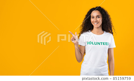 Volunteer Lady Pointing Finger At Free Space, Yellow Background, Panorama Volunteer Lady Pointing Finger At Free Space, Yellow Background, Panorama 85159759