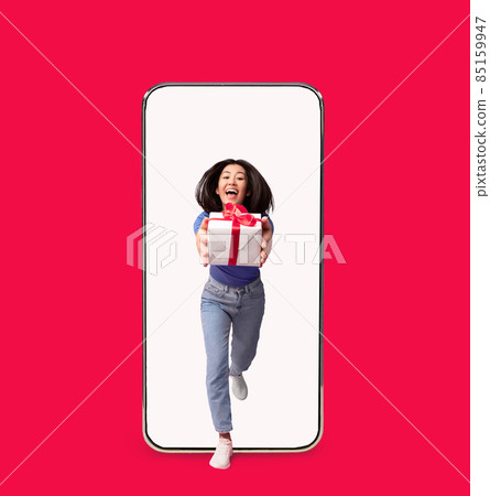 Excited Asian Woman Giving Present Box Coming Out Cell Screen 85159947