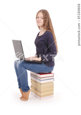Student teenage girl sitting sideways on the book with laptop Student teenage girl sitting sideways on the book with laptop 85160608