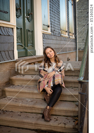 Pretty woman with curly hair near old building Pretty woman with curly hair near old building 85160824
