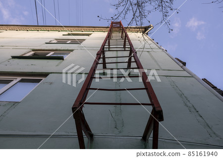 Red fire escape on the facade of a residential building. Red fire escape on the facade of a residential building. 85161940