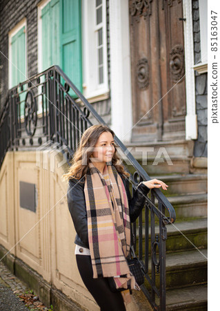 Young woman dressed warm with stairs behind 85163047